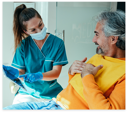 Nocatee dental team member talking to man in dental chair