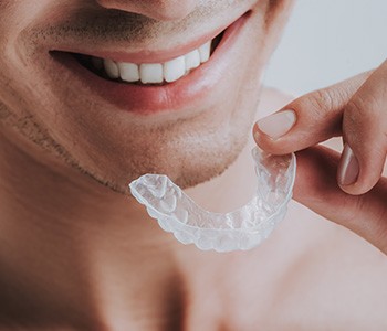 man wearing mouthguard to protect dental implants